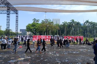 Sampah berserakan setelah ribuan massa memadati lokasi perayaan Hari Buruh
