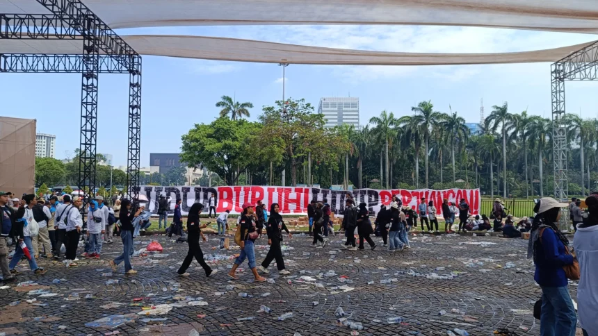 Sampah berserakan setelah ribuan massa memadati lokasi perayaan Hari Buruh