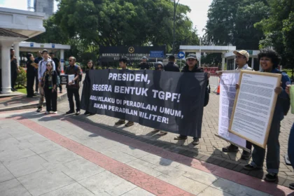 Sejumlah pimpinan organisasi masyarakat sipil yang tergabung dalam Koalisi Solidaritas untuk Andrie Yunus membentangkan spanduk dan menunjukkan surat yang akan diberikan kepada Presiden Prabowo di halaman Kantor Kementerian Sekretariat Negara, Jakarta, Jumat (17/4/2026). Surat tersebut berisikan permintaan agar Presiden memastikan penanganan kasus penyiraman air keras terhadap Wakil Koordinator KontraS Andrie Yunus secara transparan, akuntabel, dan imparsial, serta meminta pembentukan Tim Gabungan Pencari Fakta (TGPF).