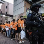 Personel kepolisian menggiring sejumlah tersangka kasus perjudian daring di Perkantoran Hayam Wuruk Plaza Tower, Jakarta, Minggu (10/5/2026). Polri memindahkan 320 orang tersangka Warga Negara Asing (WNA) dan satu orang Warga Negara Indonesia (WNI) yang diamankan dalam pengungkapan kasus perjudian daring jaringan internasional ke sejumlah kantor imigrasi untuk menjalani pemeriksaan lanjutan.