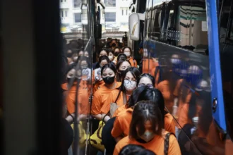 Personel kepolisian menggiring sejumlah tersangka kasus perjudian daring di Perkantoran Hayam Wuruk Plaza Tower, Jakarta, Minggu (10/5/2026). Polri memindahkan 320 orang tersangka Warga Negara Asing (WNA) dan satu orang Warga Negara Indonesia (WNI) yang diamankan dalam pengungkapan kasus perjudian daring jaringan internasional ke sejumlah kantor imigrasi untuk menjalani pemeriksaan lanjutan.