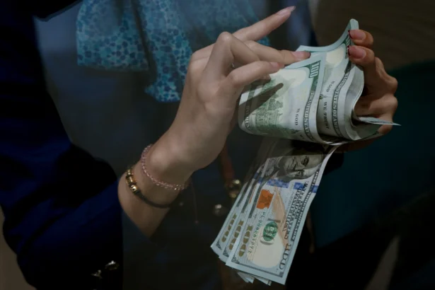 Karyawan menghitung uang pecahan dolar Amerika Serikat (AS) di gerai penukaran mata uang asing Haji La Tunrung, Makassar, Sulawesi Selatan, Rabu (20/5/2026).