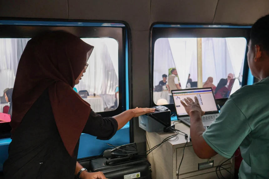 Petugas merekam sidik jari warga saat mengurus administrasi kependudukan melalui layanan kependudukan akhir pekan mobil keliling Adminduk Kabupaten Bogor di Bojonggede, Kabupaten Bogor, Jawa Barat. (Sumber: Antara Foto/Yulius Satria Wijaya/YU)