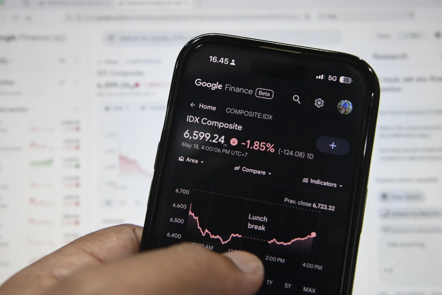 Warga mengamati grafik pergerakan Indeks Harga Saham Gabungan (IHSG) melalui ponsel pintar di Jakarta. (Sumber: Antara Foto/M Risyal Hidayat/kye)