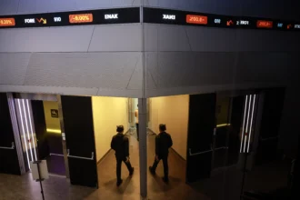 Pekerja berjalan di dekat layar digital pergerakan Indeks Harga Saham Gabungan (IHSG) di Bursa Efek Indonesia (BEI), Jakarta, Kamis (21/5/2026).