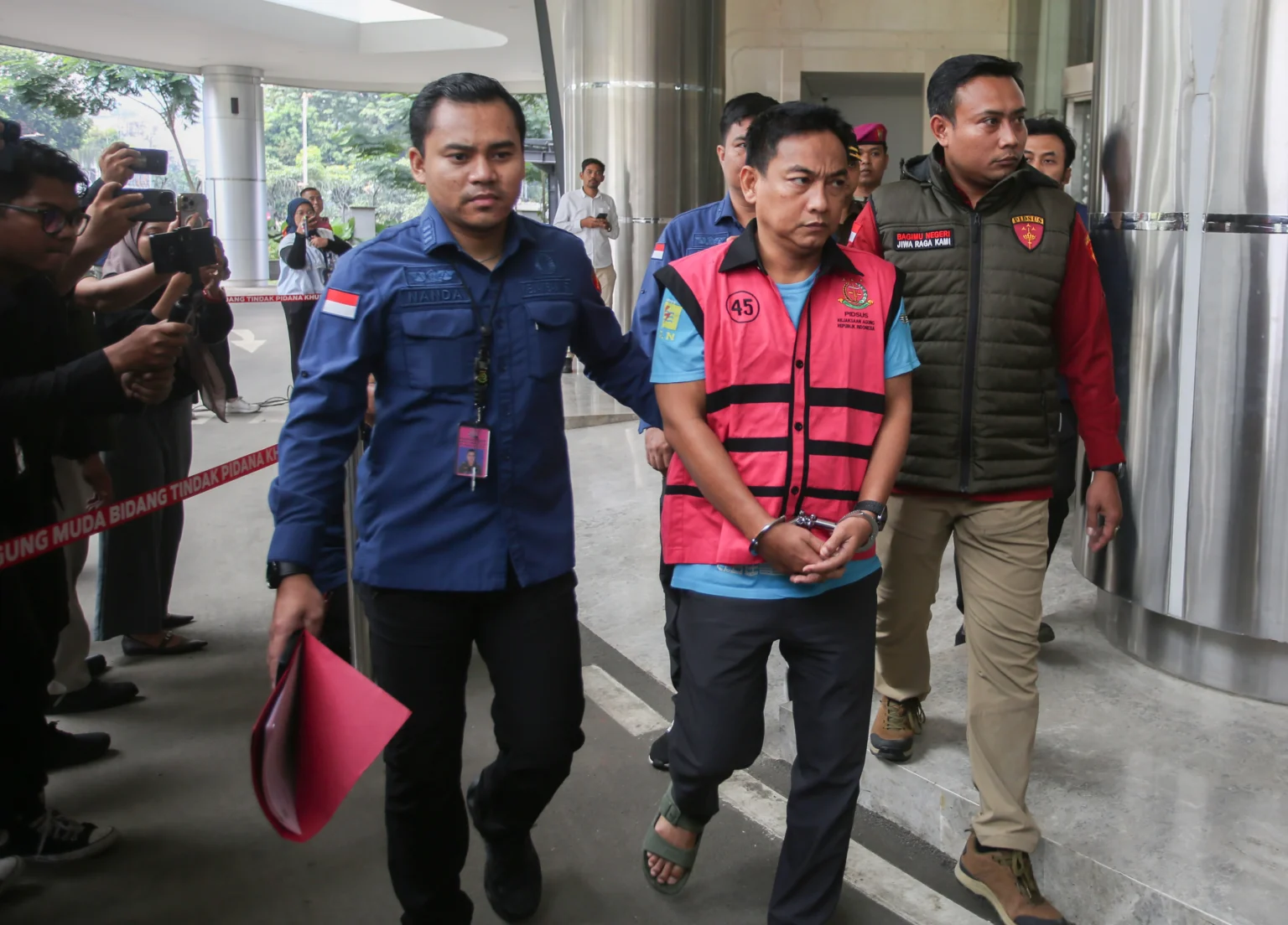 Penyidik Kejaksaan Agung mengawal Ketua Ombudsman RI 2026 - 2031 Hery Susanto (kedua kanan) seusai menjalani pemeriksaan dan penetapan tersangka di Gedung Bundar Jampidsus Kejaksaan Agung, Jakarta, Kamis (16/4/2026). Kejaksaan Agung menetapkan Ketua Ombudsman RI Hery Susanto sebagai tersangka dalam kasus korupsi tata kelola usaha pertambangan nikel di wilayah Sulawesi Utara.