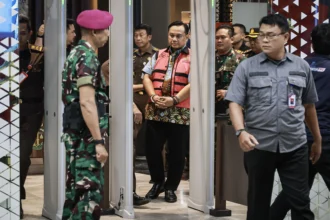 Mantan anggota Ombudsman Yeka Hendra Fatika (tengah) digiring petugas menuju mobil tahanan usai menjalani pemeriksaan di Kejaksaan Agung (Kejagung), Jakarta, Senin (25/5/2026).