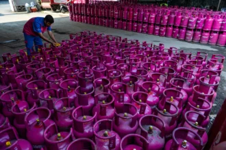 Pekerja memasang segel pada tabung gas 12 kg di distributor gas nonsubsidi di Bandung, Jawa Barat