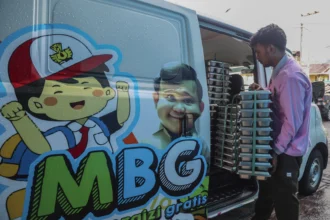 Petugas menyusun ompreng berisi makanan bergizi gratis ke dalam mobil sebelum didistribusikan kepada penerima manfaat di dapur Satuan Pelayanan Pemenuhan Gizi (SPPG) Polres Ternate di Ternate, Maluku Utara, Rabu (6/5/2026).