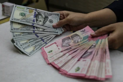 Karyawan menunjukkan uang pecahan rupiah dan dolar Amerika Serikat (AS) di gerai penukaran mata uang asing Ayu Masagung, Kwitang, Jakarta. (Sumber: Antara Foto/Darryl Ramadhan/kye)