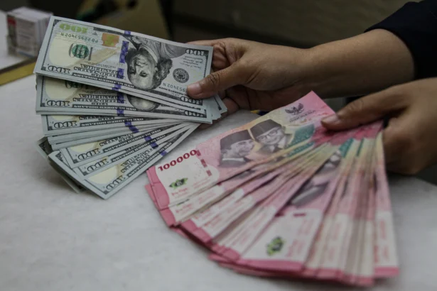 Karyawan menunjukkan uang pecahan rupiah dan dolar Amerika Serikat (AS) di gerai penukaran mata uang asing Ayu Masagung, Kwitang, Jakarta. (Sumber: Antara Foto/Darryl Ramadhan/kye)