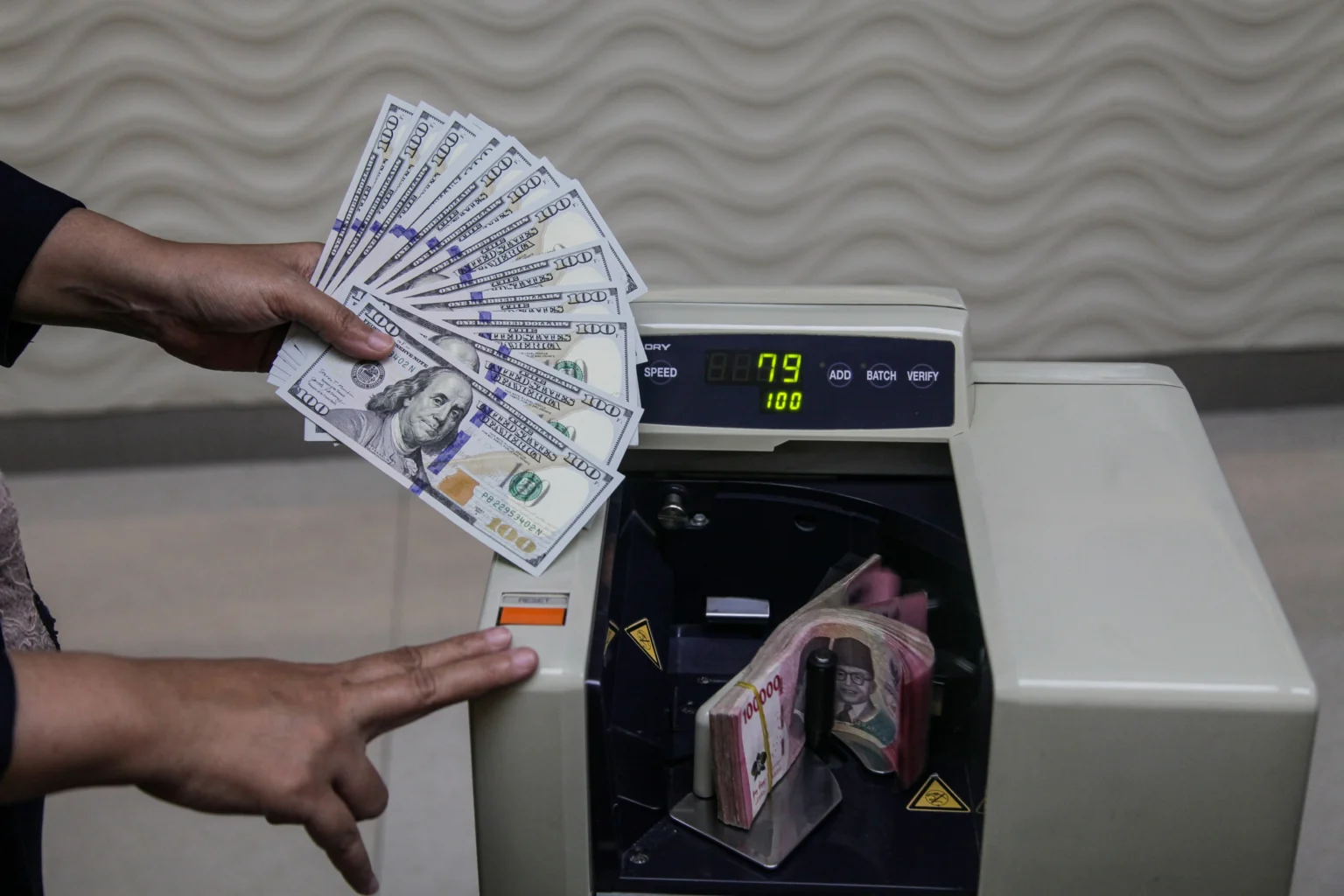 Karyawan menghitung uang pecahan rupiah dan dolar Amerika Serikat (AS) di gerai penukaran mata uang asing Ayu Masagung, Kwitang, Jakarta. (Sumber: Antara Foto/Darryl Ramadhan/kye)