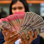 Karyawan memperlihatkan uang pecahan rupiah dan dolar Amerika Serikat (AS) di gerai penukaran mata uang asing Ayu Masagung, Jakarta. (Sumber: Antara Foto/Indrianto Eko Suwarso/kye)