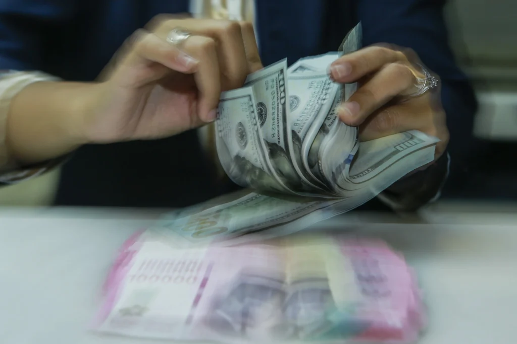 Karyawan menghitung uang pecahan rupiah dan dolar Amerika Serikat (AS) di gerai penukaran mata uang asing Ayu Masagung, Jakarta. (Sumber: Asprilla Dwi Adha/hma)