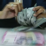 Karyawan menghitung uang pecahan rupiah dan dolar Amerika Serikat (AS) di gerai penukaran mata uang asing Ayu Masagung, Jakarta. (Sumber: Asprilla Dwi Adha/hma)