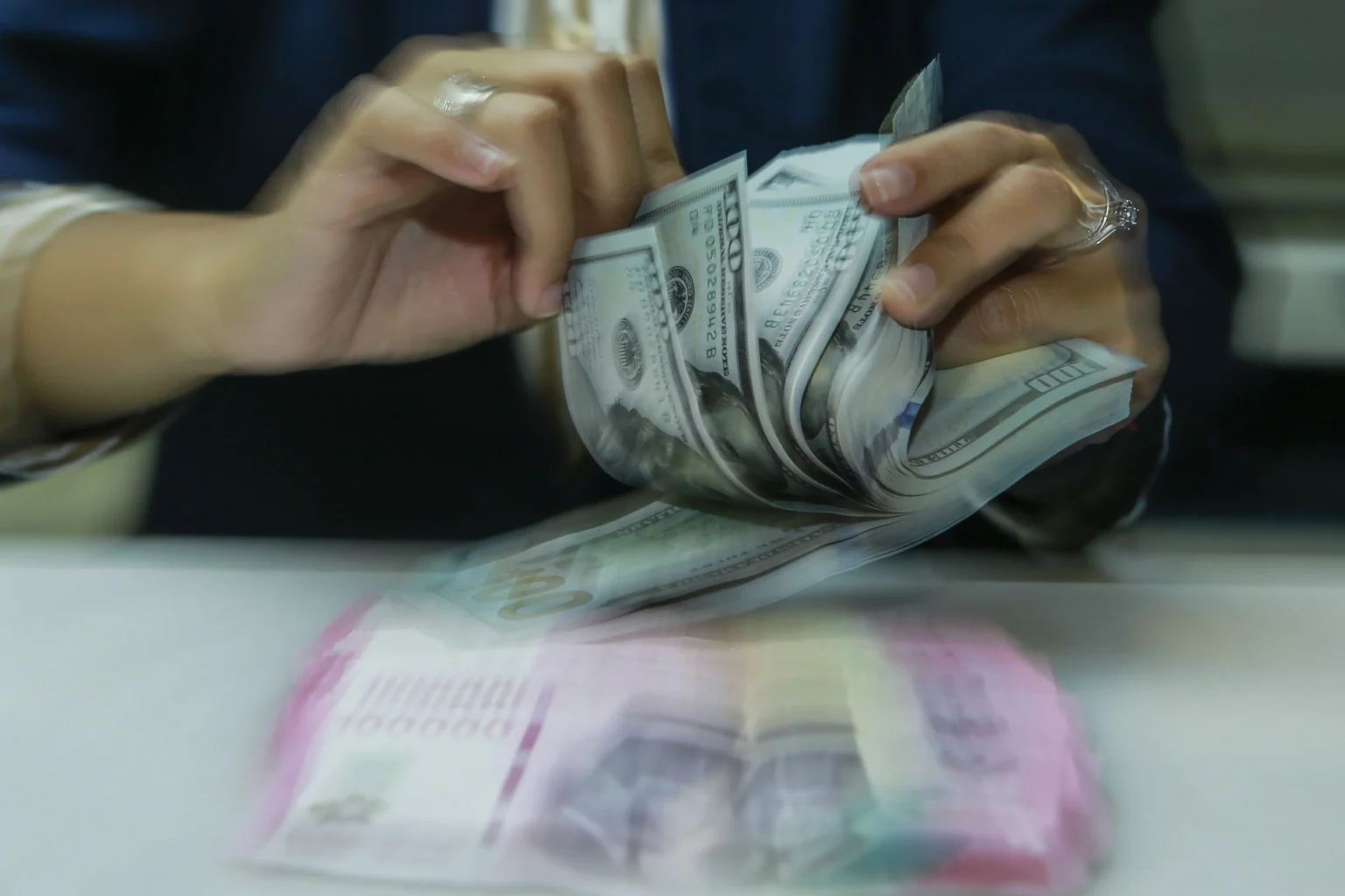 Karyawan menghitung uang pecahan rupiah dan dolar Amerika Serikat (AS) di gerai penukaran mata uang asing Ayu Masagung, Jakarta. (Sumber: Asprilla Dwi Adha/hma)