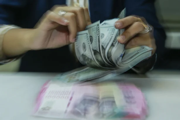 Karyawan menghitung uang pecahan rupiah dan dolar Amerika Serikat (AS) di gerai penukaran mata uang asing Ayu Masagung, Jakarta. (Sumber: Asprilla Dwi Adha/hma)