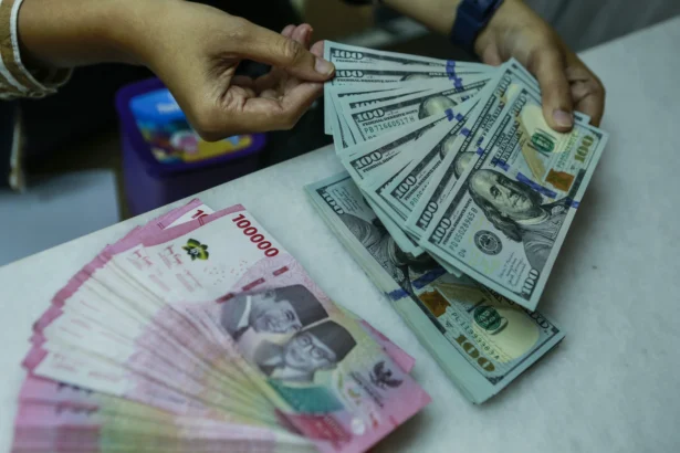 Karyawan menghitung uang pecahan rupiah dan dolar Amerika Serikat (AS) di gerai penukaran mata uang asing Ayu Masagung, Jakarta, Selasa (5/5/2026). (Sumber: Antara Foto/Asprilla Dwi Adha/hma)