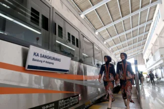 Pramugari melintas di samping gerbong Kereta Api (KA) Sangkuriang menjelang diberangkatkan saat peluncurannya di Stasiun Ketapang, Banyuwangi, Jawa Timur, Sabtu (2/5/2026). PT KAI meresmikan Kereta Api Sangkuriang relasi Banyuwangi-Bandung berjarak 1.002 kilometer dengan tiga kelas layanan yakni Kelas Compartemnt, Eksekutif dan Ekonomi sebagai upaya mempermudah konektivitas masyarakat serta mendukung sektor pariwisata.