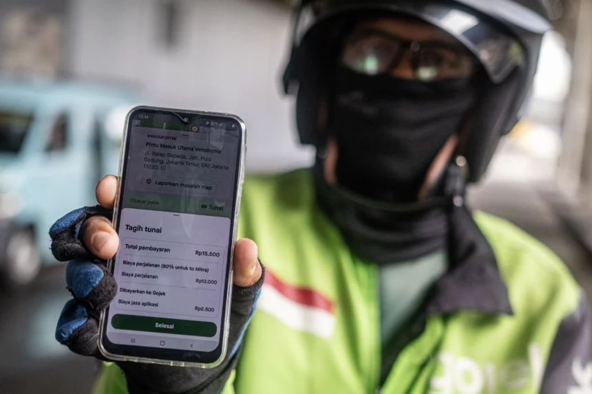 Pengendara ojek daring menunjukan bukti transaksi perjalanan di Jalan Balap Sepeda, Pulo Gadung, Jakarta, Selasa (5/5/2026). Presiden Prabowo Subianto resmi menetapkan menurunkan komisi tarif ojek daring dari 20 persen menjadi delapan persen melalui Peraturan Presiden (Perpres) Nomor 27 Tahun 2026 tentang Perlindungan Pekerja Transportasi Daring. (ANTARA FOTO/Rakha Raditya Yahya)