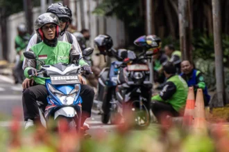 Pengendara ojek daring mengantar penumpang di kawasan Kalibata, Jakarta, Selasa (5/5/2026). Presiden Prabowo Subianto resmi menetapkan menurunkan komisi tarif ojek daring dari 20 persen menjadi delapan persen melalui Peraturan Presiden (Perpres) Nomor 27 Tahun 2026 tentang Perlindungan Pekerja Transportasi Daring. (ANTARA FOTO/Rakha Raditya Yahya)