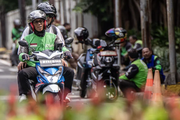 Pengendara ojek daring mengantar penumpang di kawasan Kalibata, Jakarta, Selasa (5/5/2026). Presiden Prabowo Subianto resmi menetapkan menurunkan komisi tarif ojek daring dari 20 persen menjadi delapan persen melalui Peraturan Presiden (Perpres) Nomor 27 Tahun 2026 tentang Perlindungan Pekerja Transportasi Daring. (ANTARA FOTO/Rakha Raditya Yahya)