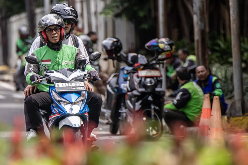 Pengendara ojek daring mengantar penumpang di kawasan Kalibata, Jakarta, Selasa (5/5/2026). Presiden Prabowo Subianto resmi menetapkan menurunkan komisi tarif ojek daring dari 20 persen menjadi delapan persen melalui Peraturan Presiden (Perpres) Nomor 27 Tahun 2026 tentang Perlindungan Pekerja Transportasi Daring. (ANTARA FOTO/Rakha Raditya Yahya)