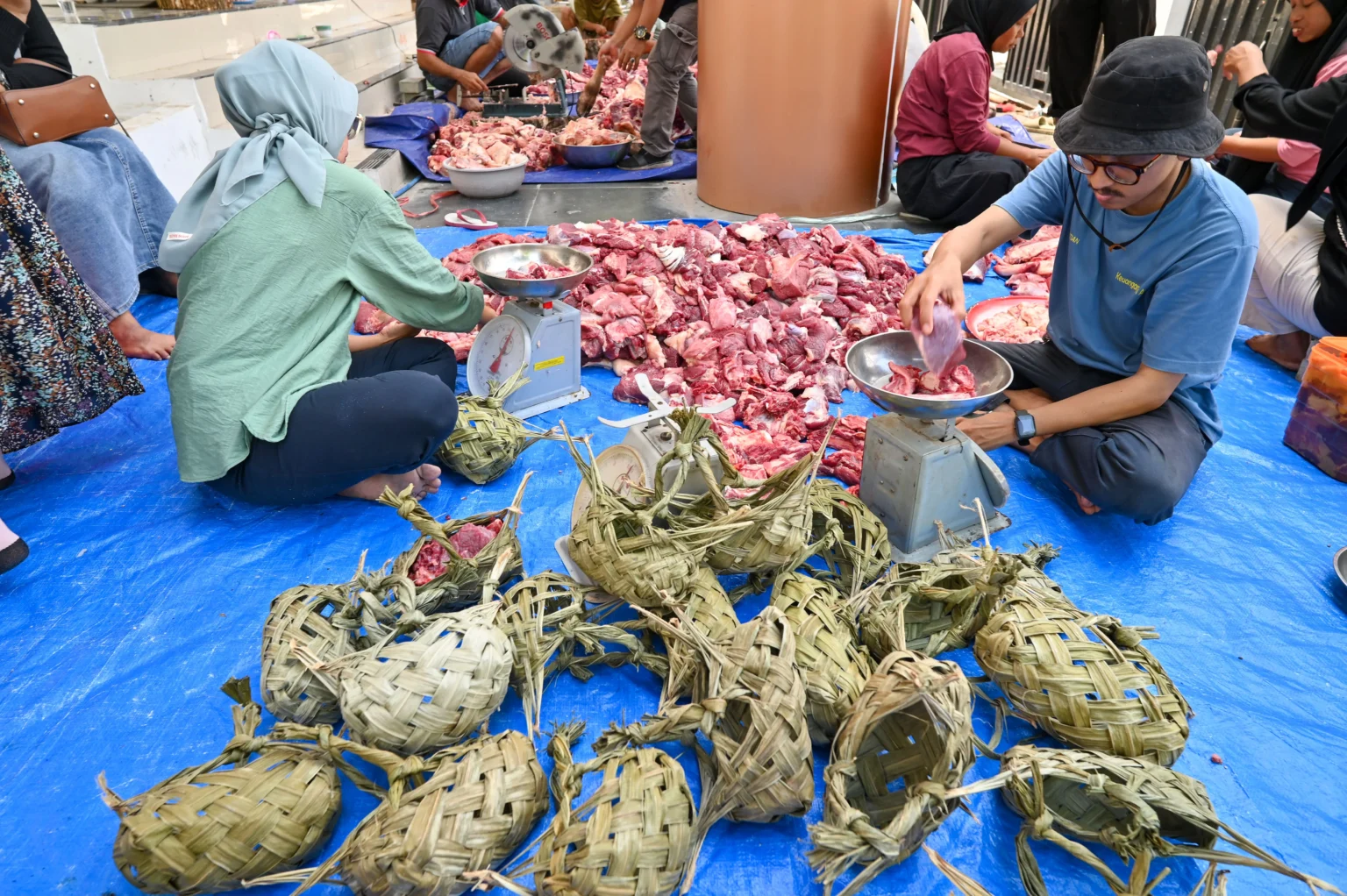 Petugas menimbang daging kurban sebelum dikemas dengan menggunakan kamboti (keranjang terbuat dari daun silar) di Kantor Dinas Lingkungan Hidup Kota Palu, Sulawesi Tengah