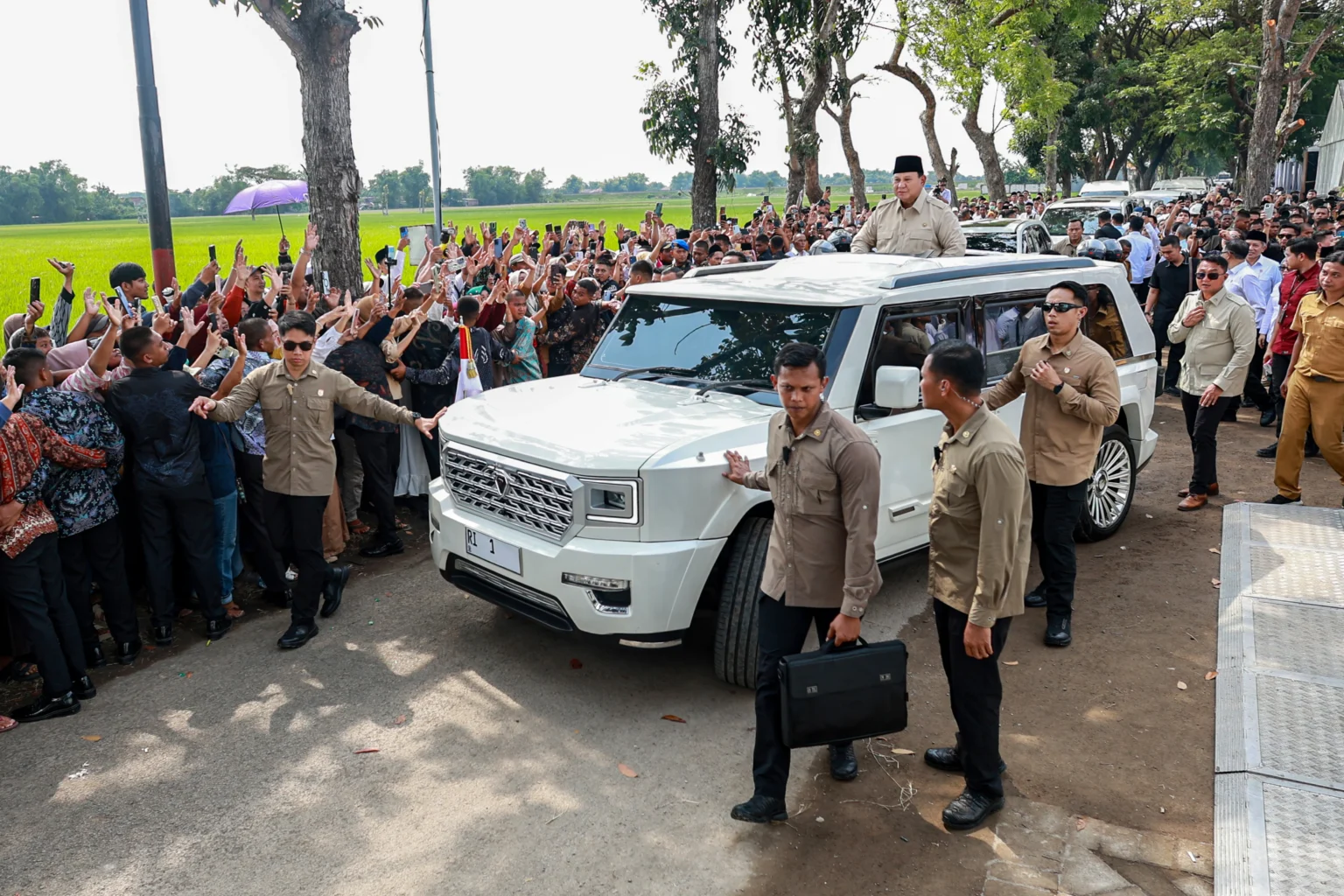 Presiden Prabowo Subianto menyapa warga dari mobil kepresidenan saat peresmian Koperasi Desa/Kelurahan Merah Putih (KDMP/KKMP) di Nglawak, Nganjuk, Jawa Timur, Sabtu (16/5/2026). Presiden Prabowo Subianto meresmikan sedikitnya 1.061 Koperasi Desa/Kelurahan Merah Putih (KDMP/KKMP) yang siap beroperasi di Jawa Timur dan Jawa Tengah dengan tujuan sebagai penggerak ekonomi desa dan memperluas akses masyarakat terhadap sembako murah.
