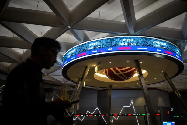 Pengunjung melintas di depan layar yang menampilkan pergerakan Indeks Harga Saham Gabungan (IHSG) di Bursa Efek Indonesia, Jakarta, Jumat (24/4/2026).