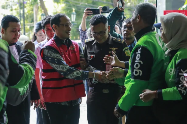 Terdakwa kasus dugaan korupsi pengadaan Chromebook dalam program digitalisasi pendidikan di Kemendikbudristek Nadiem Makarim (kedua kiri) menyapa pengemudi Gojek saat mengikuti sidang lanjutan di Pengadilan Tipikor, Jakarta