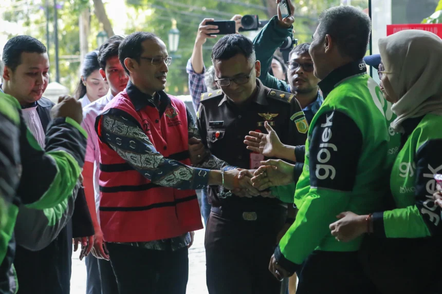 Terdakwa kasus dugaan korupsi pengadaan Chromebook dalam program digitalisasi pendidikan di Kemendikbudristek Nadiem Makarim (kedua kiri) menyapa pengemudi Gojek saat mengikuti sidang lanjutan di Pengadilan Tipikor, Jakarta