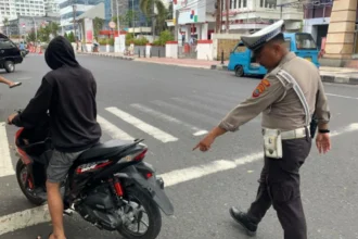 Petugas lalu lintas saat menegur pengendara motor.