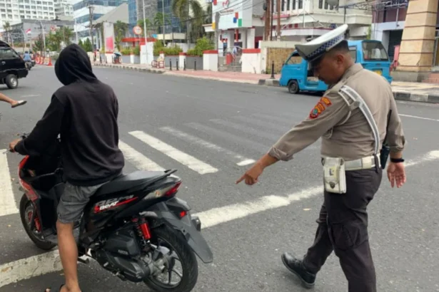 Petugas lalu lintas saat menegur pengendara motor.