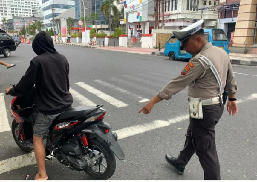 Petugas lalu lintas saat menegur pengendara motor.