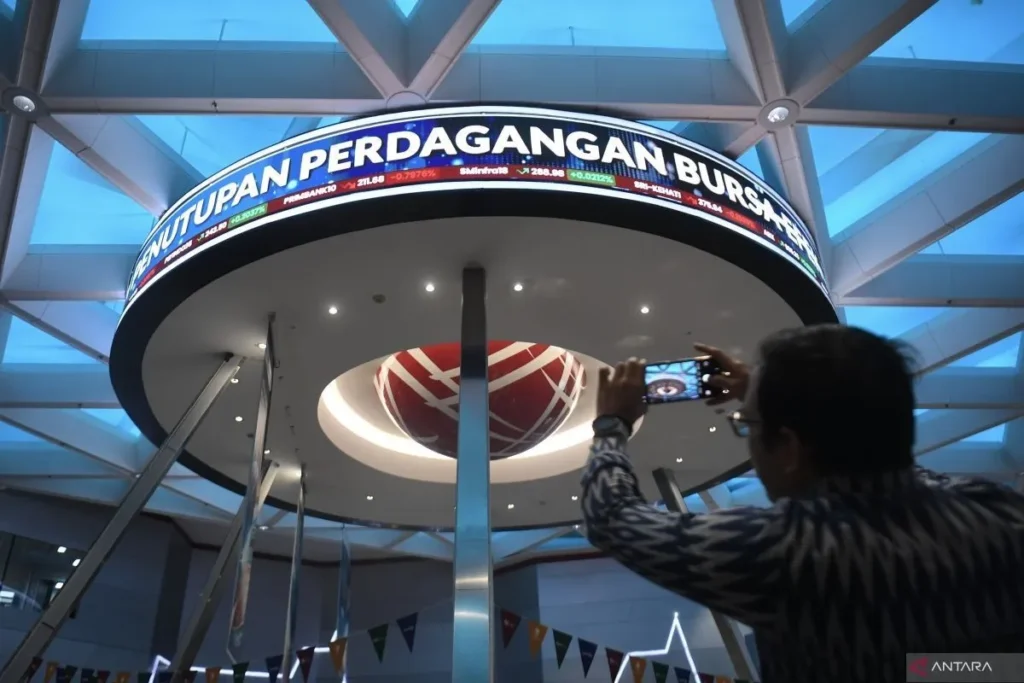 Seorang pengunjung mengambil gambar pergerakan perdagangan saham di Bursa Efek Indonesia (BEI), Jakarta, Senin (30/12/2024).