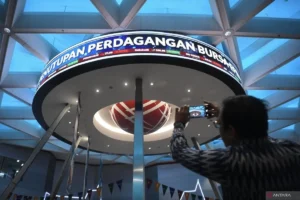 Seorang pengunjung mengambil gambar pergerakan perdagangan saham di Bursa Efek Indonesia (BEI), Jakarta, Senin (30/12/2024).