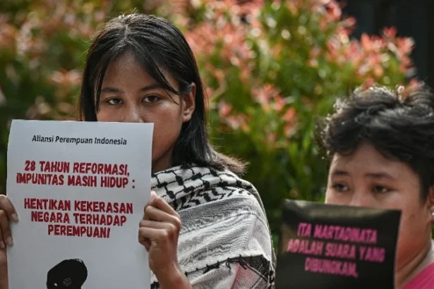 Aktivis yang tergabung dalam Aliansi Perempuan Indonesia membawa poster saat aksi.