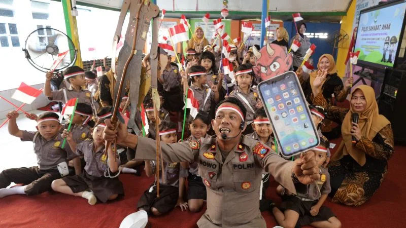 Anggota polisi memainkan wayang edukasi pada program Polisi Sahabat Anak di TK Kemala Bhayangkari 42, Kota Kediri, Jawa Timur.
