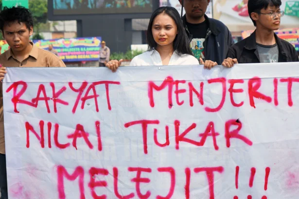 Mahasiswa yang tergabung dalam Liga Mahasiswa Nasional untuk Demokrasi (LMND) dengan mulut terjahit memajang spanduk ketika berunjuk rasa di Tugu Adipura, Bandar Lampung, Lampung, Rabu (10/6/2026).