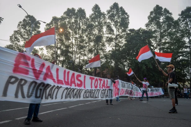 Sejumlah peserta aksi yang tergabung dalam Lingkar Aspirasi Publik (LAP) membentangkan spanduk saat unjuk rasa di Tugu Adipura, Kota Tangerang, Banten, Rabu (10/6/2026).