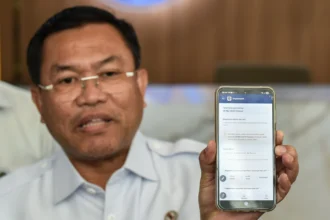 Wakil Kepala BGN Sony Sonjaya menunjukkan aplikasi Reviu Menu Makan Bergizi Gratis (MBG) dari telepon pintar di Kantor Pusat BGN, Jakarta, Selasa (26/5/2026).
