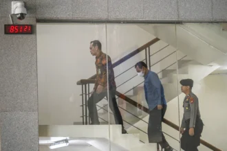 Bupati Muara Enim Edison (tengah) dikawal petugas setibanya di Gedung Merah Putih KPK, Jakarta, Selasa (9/6/2026).