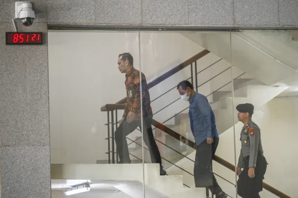 Bupati Muara Enim Edison (tengah) dikawal petugas setibanya di Gedung Merah Putih KPK, Jakarta, Selasa (9/6/2026).