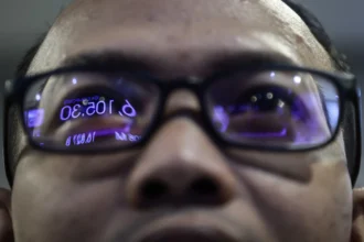 Pekerja mengamati layar pergerakan Indeks Harga Saham Gabungan (IHSG) di Bursa Efek Indonesia (BEI), Jakarta, Kamis (21/5/2026).