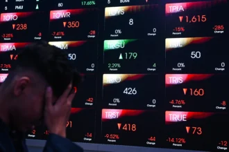Warga melintas di depan layar digital pergerakan Indeks Harga Saham Gabungan (IHSG) di Bursa Efek Indonesia, Jakarta, Rabu (3/6/2026).