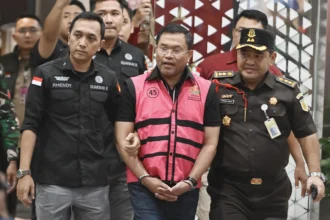 Tersangka dugaan tindak pidana korupsi tata kelola program Makan Bergizi Gratis (MBG) pada Badan Gizi Nasional (BGN) Sony Sonjaya (tengah) berjalan memasuki mobil tahanan di Kejaksaan Agung, Jakarta, Rabu (3/6/2026).