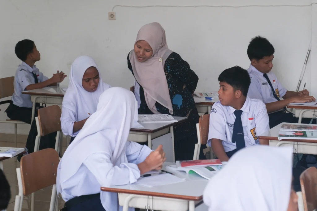 Guru membimbing siswi mengerjakan soal saat proses belajar mengajar di SRMP 25 Kendari, Sulawesi Tenggara, Selasa (26/5/2026).