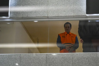 Bupati Muara Enim Edison (kiri) berjalan dengan mengenakan rompi tahanan usai menjalani pemeriksaan di Gedung Merah Putih KPK, Jakarta, Selasa (9/6/2026).
