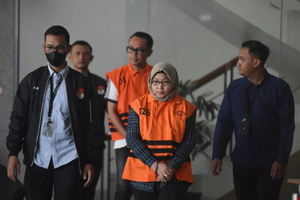 Dua tersangka kasus dugaan suap pengaturan temuan pemeriksaan BPK di Pemkab Muara Enim, Titin Rita Lestari (kedua kanan) dan Augus Dwianggara (tengah) berjalan menuju mobil tahanan usai menjalani pemeriksaan di Gedung Merah Putih KPK, Jakarta, Kamis (11/6/2026).